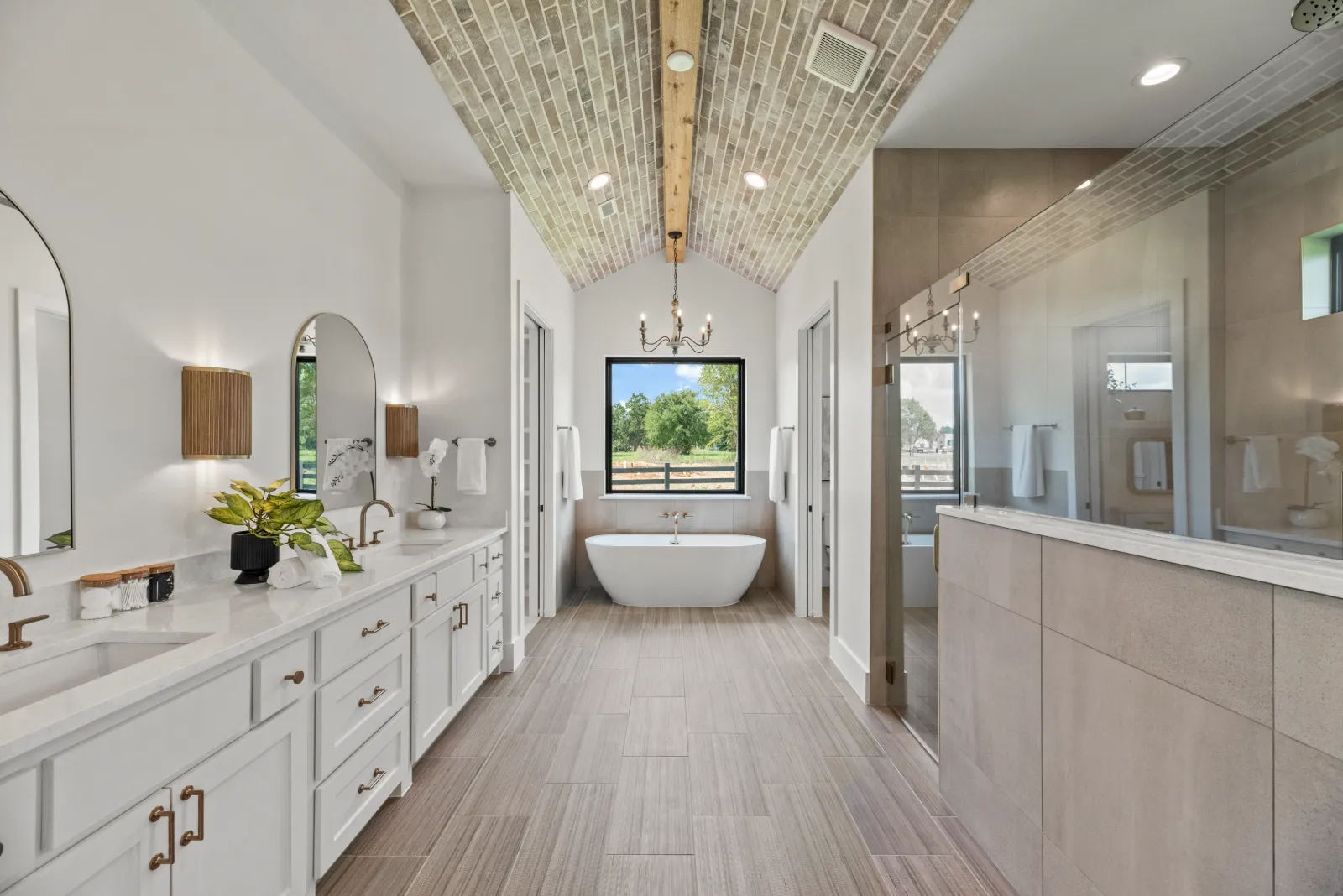 Primary bathroom beneath a brick-clad vaulted ceiling, laid by hand