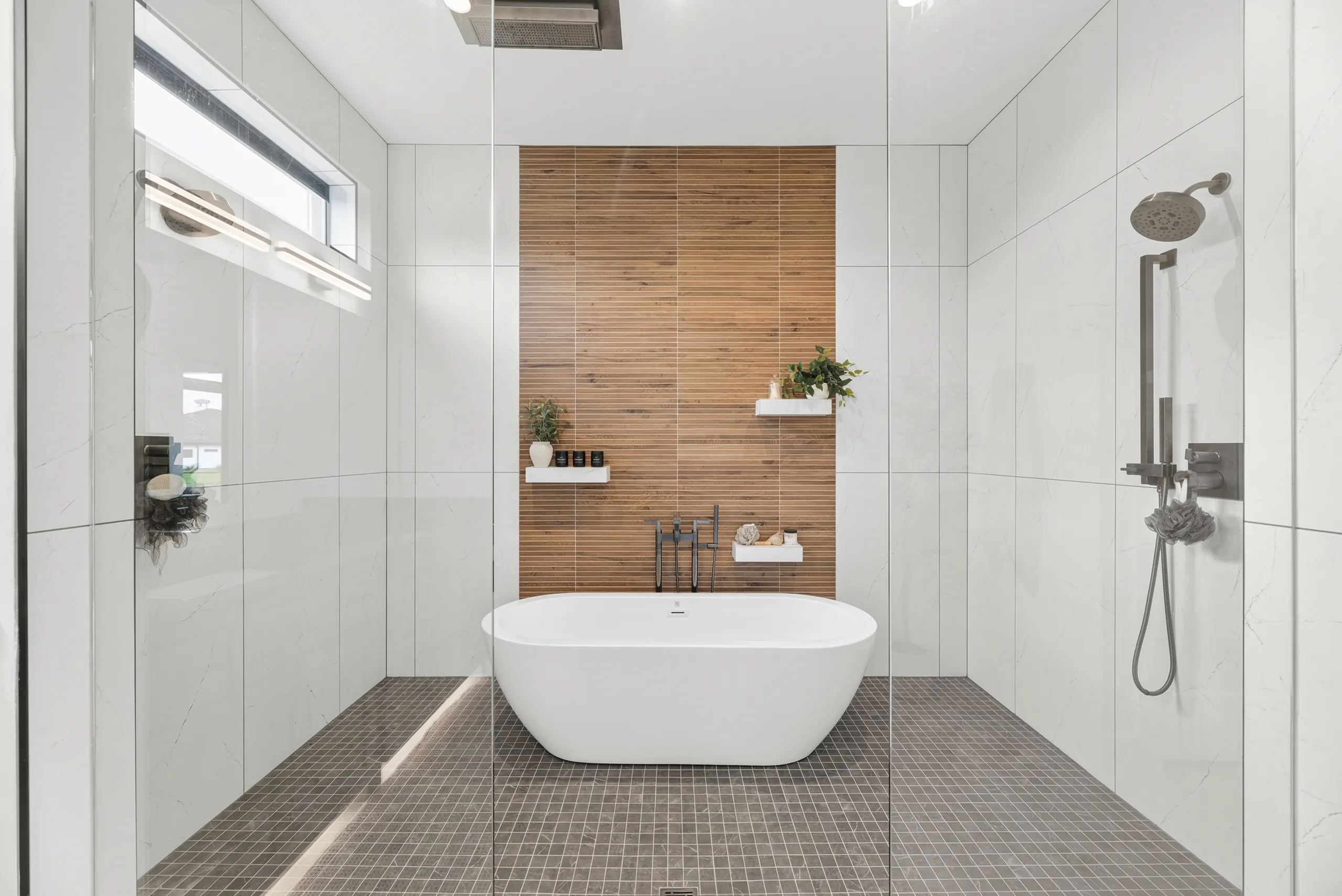 Wet room with freestanding tub and wood-slat feature wall